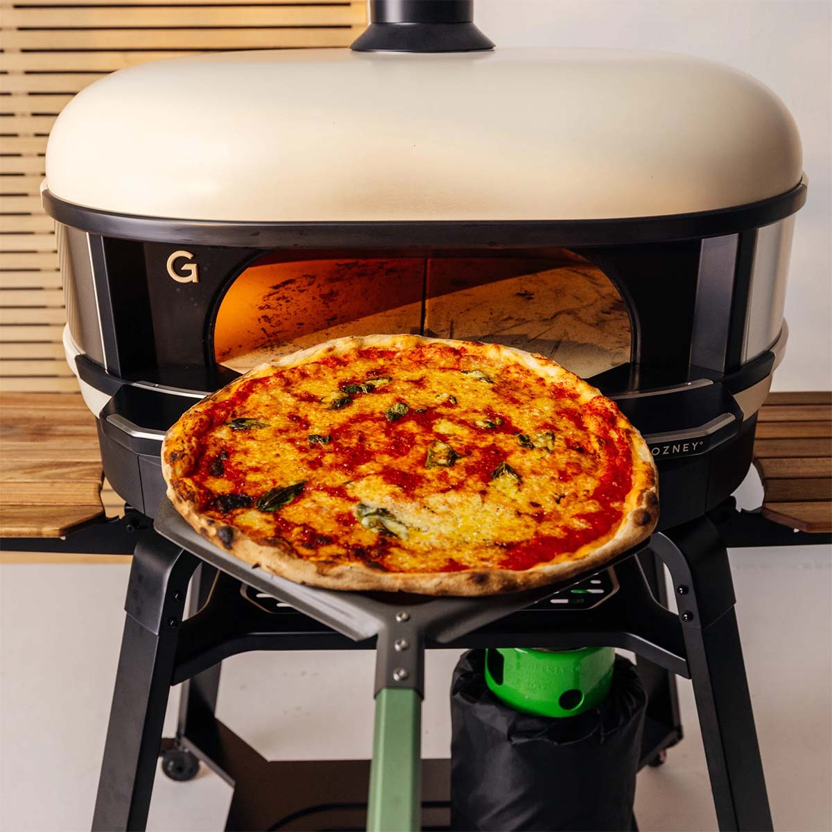 Gozney Pro Pizzaschieber mit Pizza vor Pizzaofen